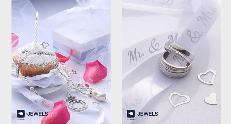 2 Ringe mit Schleifenband für eine Hochzeit dekoriert. Silberschmuck dekoriert auf Muffin mit Kerze und Geschenkpackung.