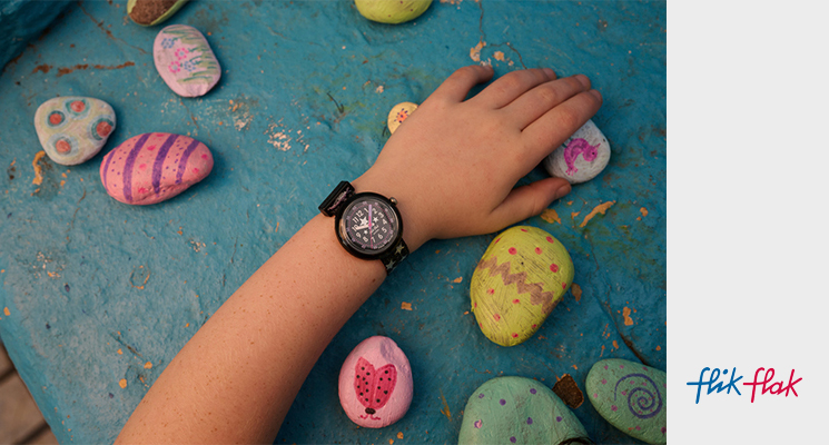 Flik Flak Kinderuhr in der Farbe schwarz, lila mit Sternenmuster am Handgelenk eines Kindes