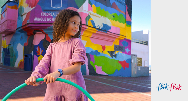 Flik Flak Kinderuhr in der Farbe schwarz, lila mit Sternenmuster am Handgelenk eines Kindes
