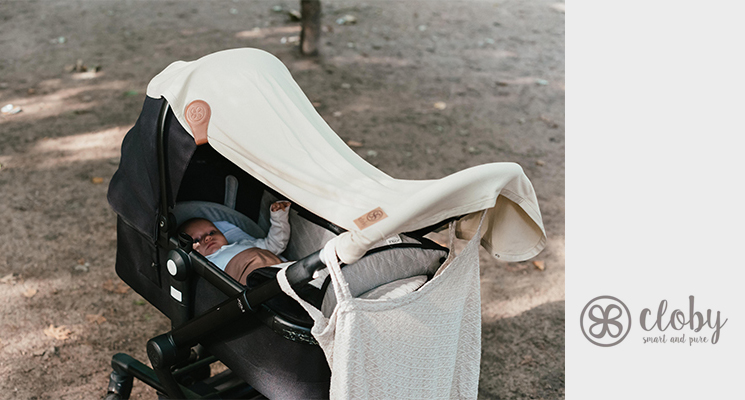 Kinderwagen mit weißer UV-Decke von Cloby, befestigt mit einem Cloby Magnetclip