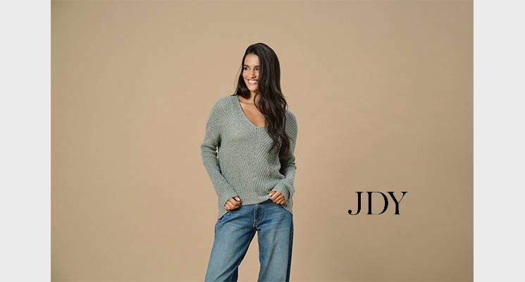 Frau mit grünem Strickpullover und großem V-Ausschnitt von only