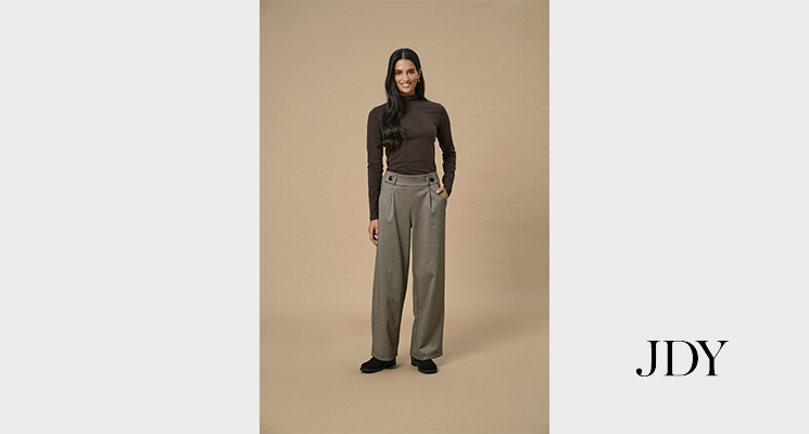 Frau mit karierter Hose und braunem Rolli von Only