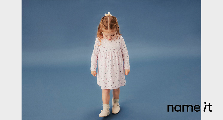 Mädchen in geblümten hellen Kleid von name it