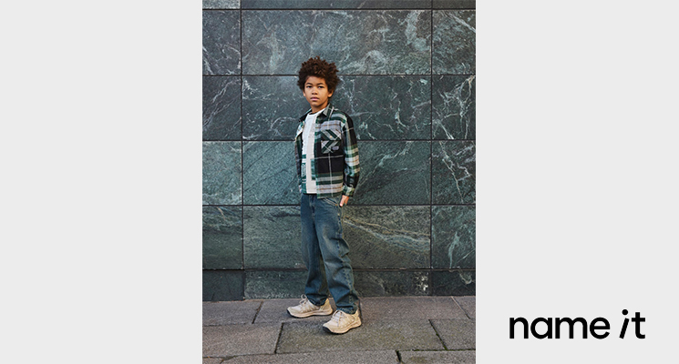 Junge mit weißem T-Shirt, blauer Jeans und karierter Jacke von name-it