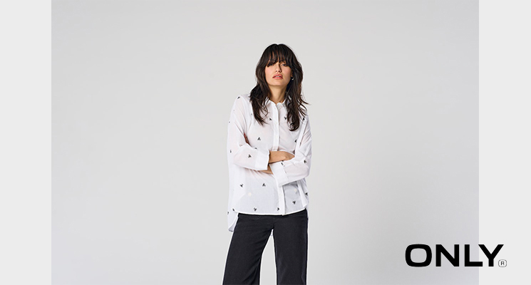 Frau mit Weißer Bluse und kleinen schwarzen Schleifen von Only