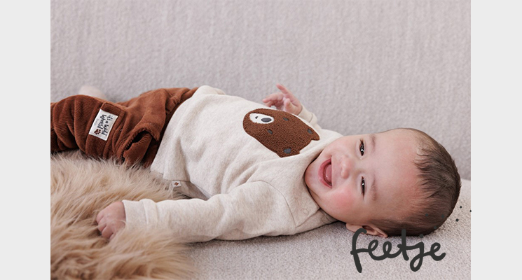 Kind brauner Hose und beige Oberteil mit Teddy von feetje