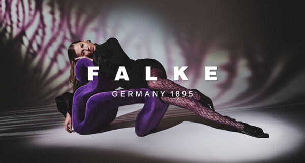 Frau in Kleid und schwarzer Strumpfhose von Falke, die auf Sessel liegt