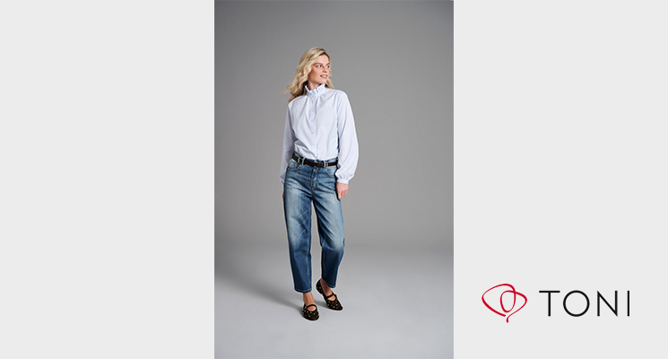 Frau mit hellblau gestreiftem Hemd und Jeandshose von Toni