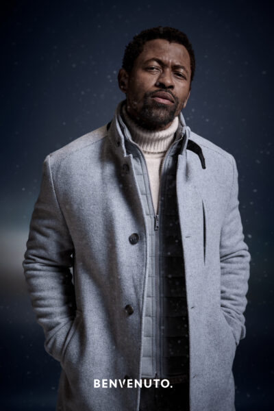 Mann mit grauem Mantel, Weste und naturfarbenen Rollkragenpullover von Benvenuto