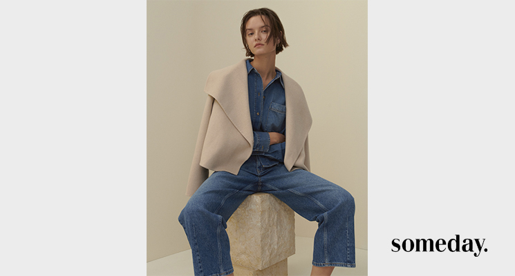 Frau sitzend mit Jeansbluse und cremefarbenen Jäckchen und blauer Jeans von Someday