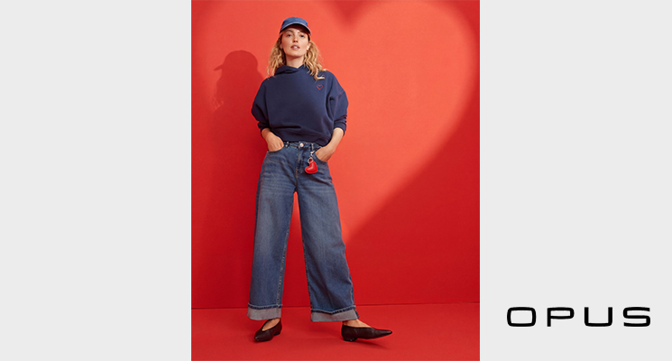 Frau mit blauem Hoodie und blauem Cap mit Herzmotiv und blauer Jeans zum Valentinstag von Opus