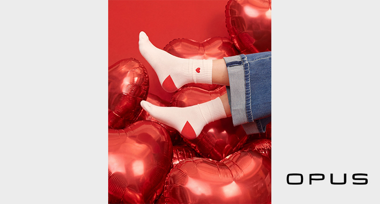 Füße mit weißen Herzmotivsocken und blauer Jeans zum Valentinstag von Opus