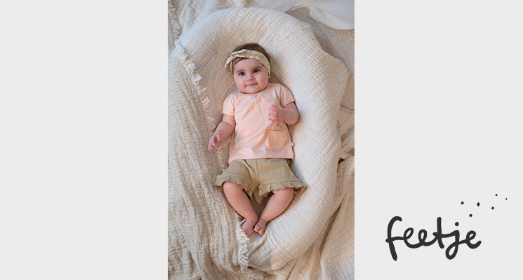 Baby Mädchen in rosa Oberteil und khaki kurzer Hose von Feetje