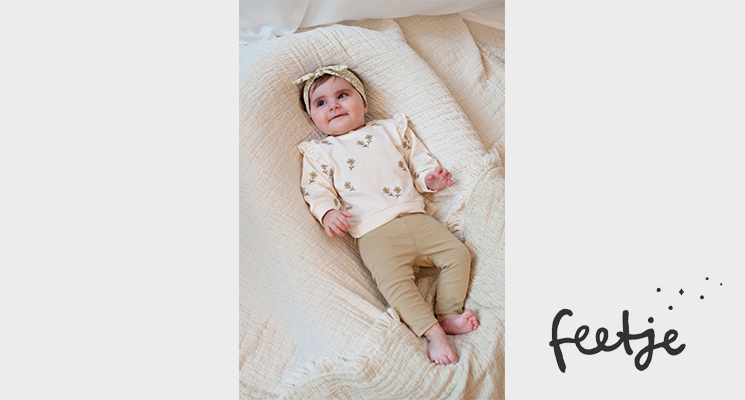 Baby Mädchen mit cremefarbenen Oberteil und beiger Hose von Feetje