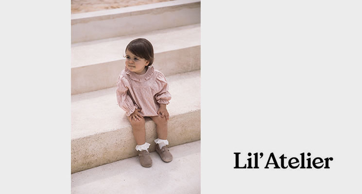 Kind mit rosafarbenen Rüschcenbody und beiger Hose sitzend auf Treppe von Lil Atelier