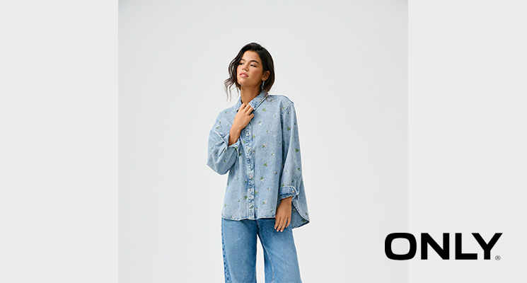 Frau stehend mit blauem Jeanshemd mit Muster und blauer Jeanshose von Only