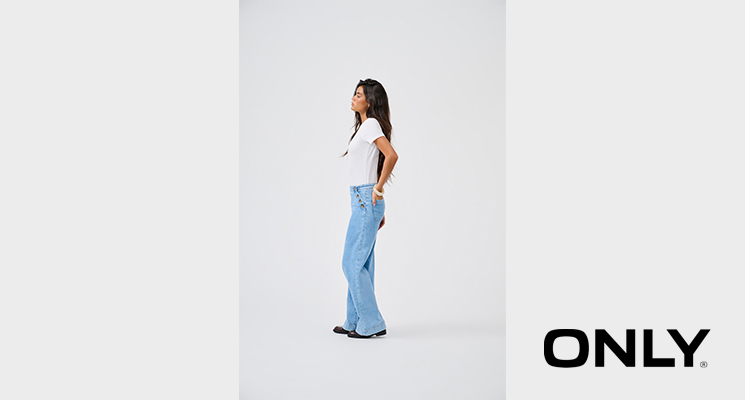 Frau seitlich stehend mit weißem T-Shirt und blauer Jeanshose von Only