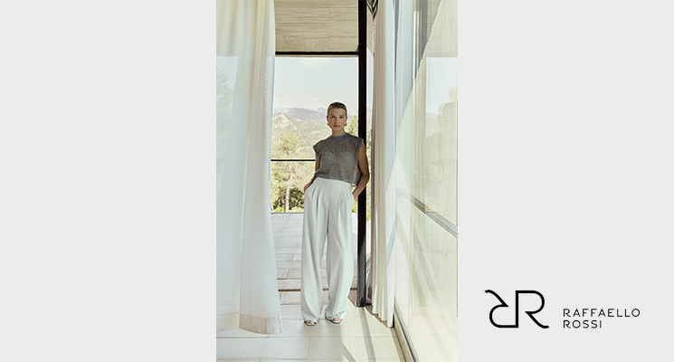 Frau stehend in durchsichtigem braunem Shirt und weißer Stoffhose von Raffaello Rossi