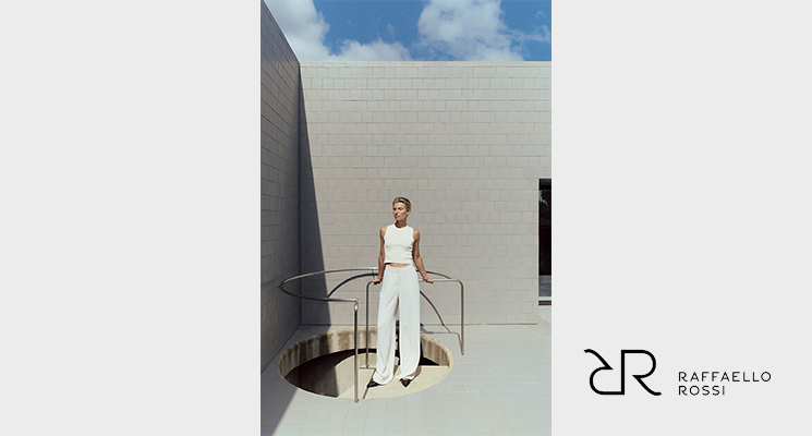 Frau stehend mit weißem Top und weißer Hose von Raffaello Rossi