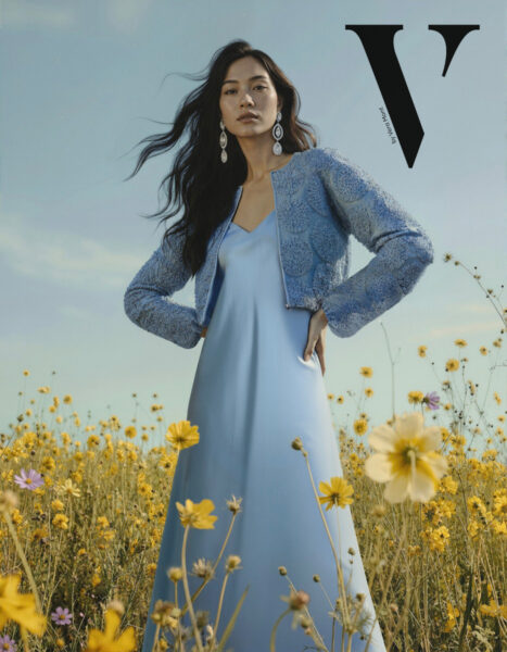 Frau auf Wiese stehend in hellblauem festlichen Kleid und blauem Jäckchen