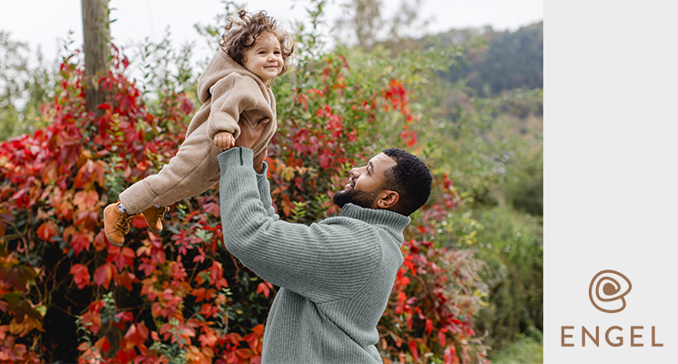 Mann hält Kind hoch mit warmen Anzug in beige von Engel