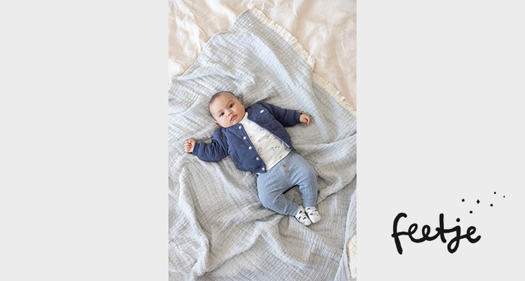 Baby in weißem Shirt mit dunkelblauer Knopfjacke und hellblauer Hose von Feetje