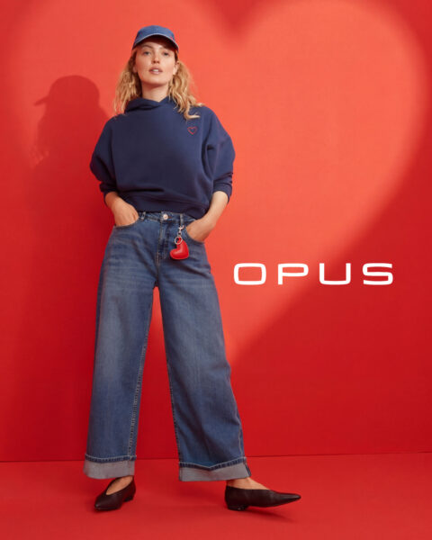 Frau mit blauem Hoodie und blauem Cap mit Herzmotiv und blauer Jeans zum Valentinstag von Opus