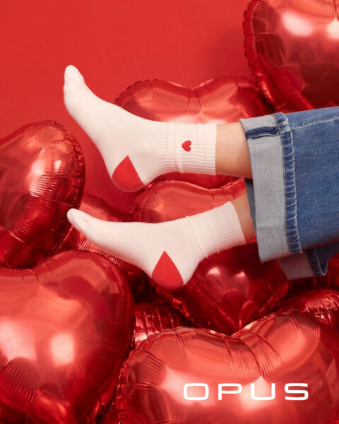 Füße mit weißen Herzmotivsocken und blauer Jeans zum Valentinstag von Opus