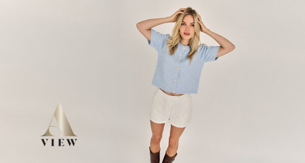 Frau mit Strickjacke in hellblau mit kurzen Ärmeln und weißer kurzer Hose von A-View