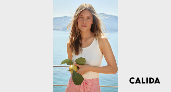 Frau in Unterhemd und Schlafanzughose von Calida mit Zitrone in der Hand