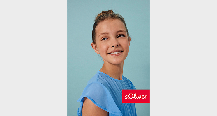 Läcehlndes Mädchen in hellblauen seidigen T-Shirt von S.Oliver