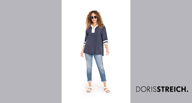 Frau in dunkelblauem Shirt mit weißem Kragen und Armabschlüssen und blauer Jeans von Doris Streich