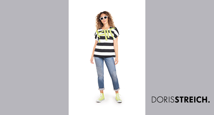 Dame in gestreiftem Shirt schwarz/weiß mit neongrünem Druck und Jeanshose von Doris Streich