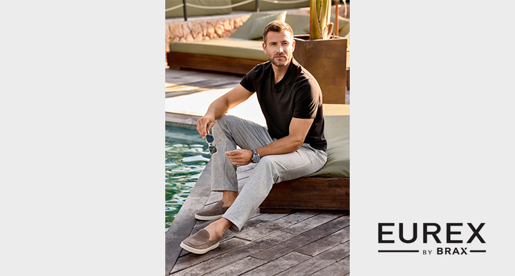 Sitzender Mann mit V-Ausschnittshirt und hellgrauer Hose von Eurex