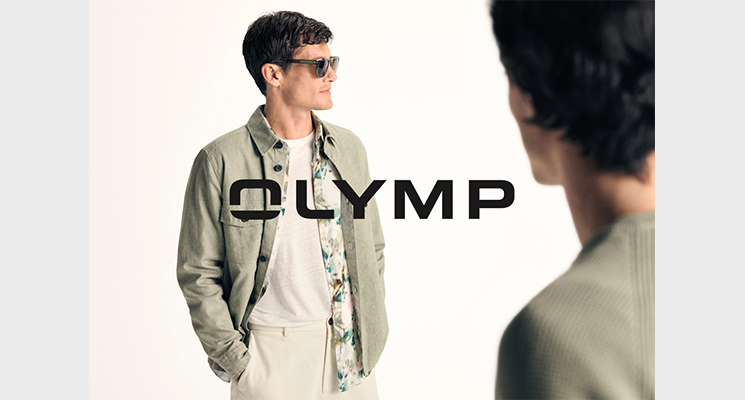 Mann mit khakifarbener Jacke und Hemd mit Blütenmuster sowie beiger Hose von Olymp