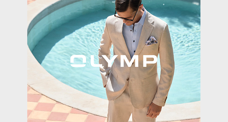 Mann in beigem Anzug mit hellblauem Hemd und Einstecktuch von Olymp