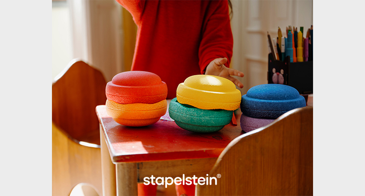 Bunte Stapelsteine auf Schreibtisch aufeinander gelegt