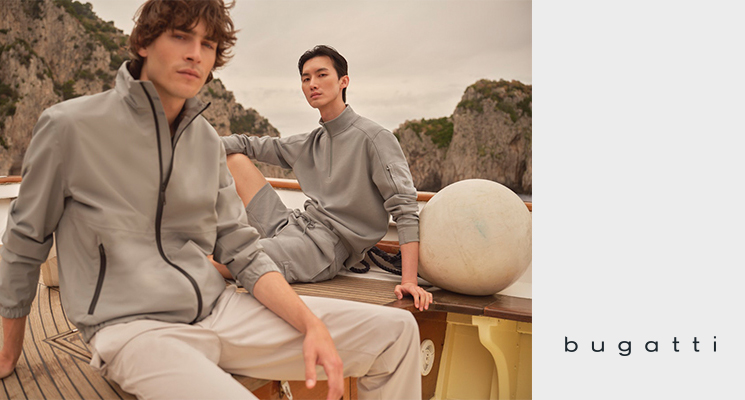 2 sitzende Männer in beigen Pullovern und beigen Hosen von Bugatti