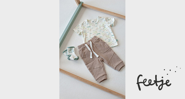 Gelegtes Outfit bestehend aus weiß gemustertem T-Shirt und beiger Hose von Feetje