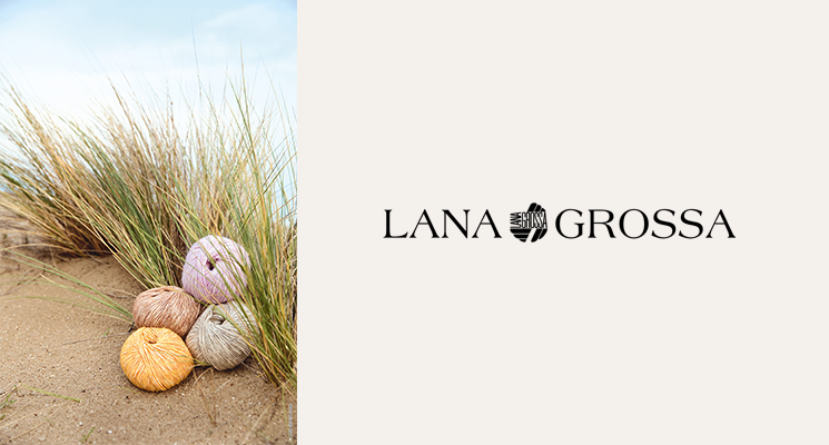 3 Wolleknäuel in orange, grün, beige und violett am Strand liegend