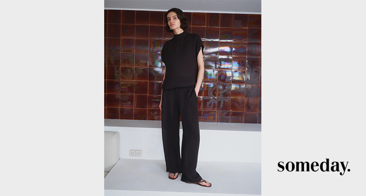 Stehende Frau in schwarzem Shirt und Hose von Someday