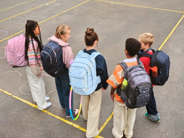 5 Kinder mit Satch Schulrucksäcken in verschiedenen Farben und Mustern