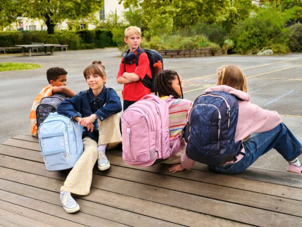 5 Kinder mit Satch Schulrucksäcken in verschiedenen Farben und Mustern