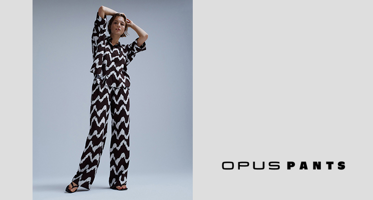 Stehende Frau in OPUS PANTS und passendem Oberteil in schwarz weiß