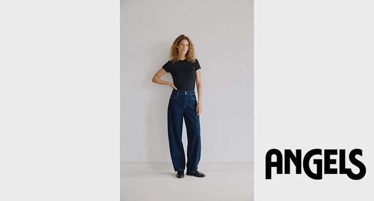Stehende Frau trägt schwarzes T-Shirt und dunkelblaue Jeans von Angels