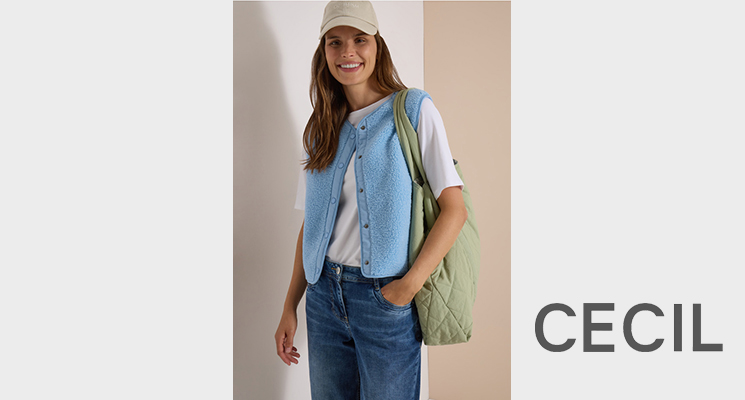Stehende Frau mit hellblauer Teddy Weste darunter weißes T-Shirt und blaue Jeans von Cecil