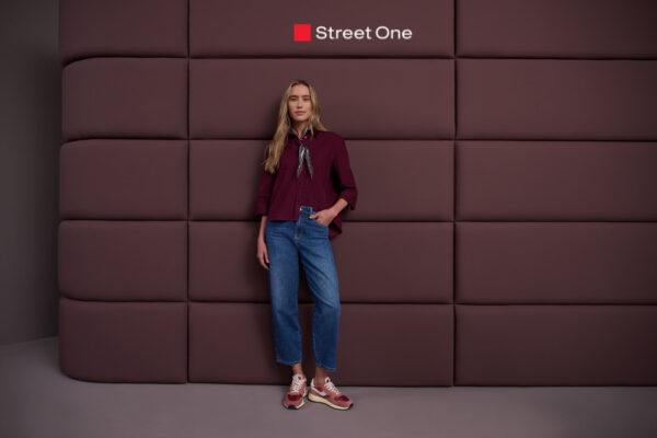 Dame mit bordeauxfarbener Bluse und blauer Jeans von Street One