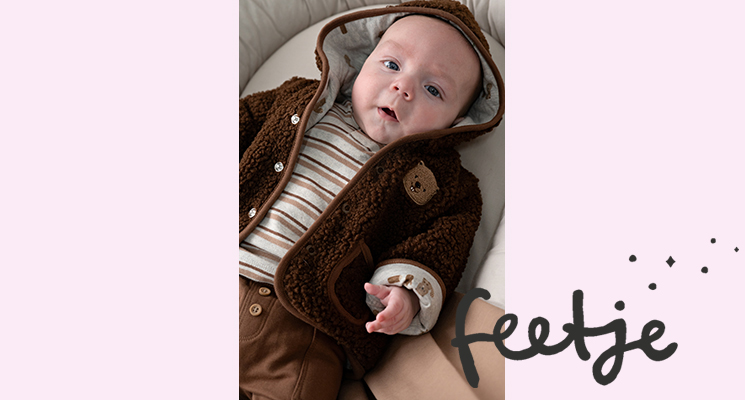 Baby Junge trägt braune Teddyjacke mit Kapuze und weißes Langarmshirt mit Streifen und braune Hose von Feetje