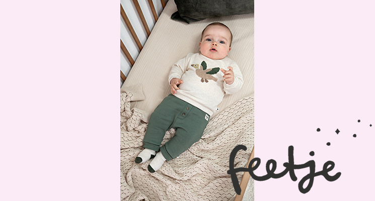 Baby Junge trägt cremefarbenes Langarmshirt mit Vogelmotiv dazu khakifarbene Stoffhose mit Knöpfen von Feetje