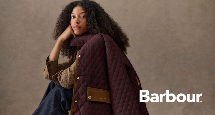 Sitzende Frau mit bordeauxfarbener Jacke von Barbour